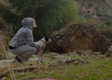 Bir kadın, ormanda yürürken köpeğiyle manzaranın tadını çıkarmak için durur.