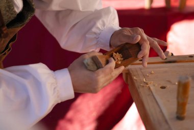 Tahtada çalışan marangoz olan tanınmayan biri.