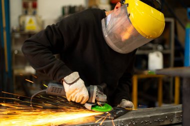 Demir çalışırken korunan metal endüstrisi işçisi.