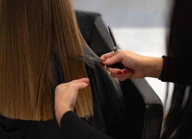 Ellerinizi makas ve tarak ile kapayın ve bir kızın saçını kesin.