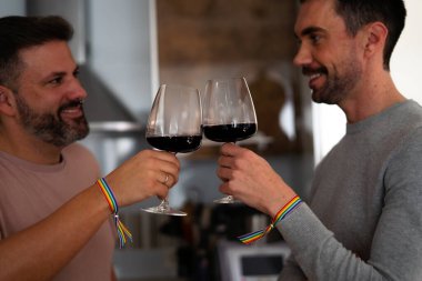 İki Igtbi erkeği evlerinin mutfağında kadehlerini şarap ile kaldırıyorlar.