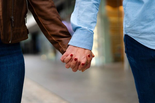  молодая пара, держась за руки во время прогулки по городу