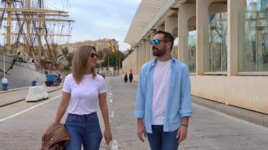 Güneş gözlüklü mutlu çift Malaga 'da yürüyor.