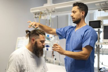 Hastane odasına oksijen maskesi takarak hastaya yardımcı olan hemşire.