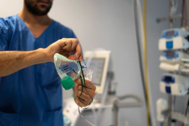 Cerrah ameliyathanede oksijen maskesi hazırlıyor.