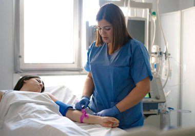 Hemşire bir hastayı kan testine hazırlamak için koluna bir turnike uyguladı.