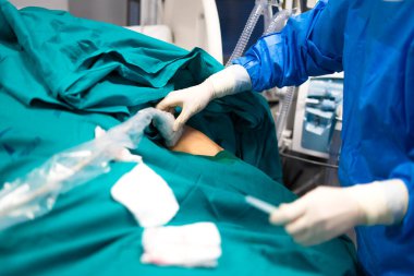 Steril ameliyathane ortamında cerrahi aletler kullanan cerrah.