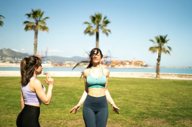 Deniz kenarındaki bir parkta yoga yapan iki kadın jimnastik hocası, sağlık ve sağlığı destekliyor.