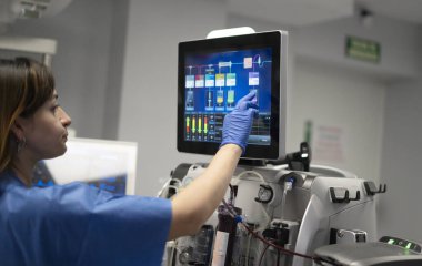 Hastanede diyaliz makinesinin ayarlarını ayarlayan teknisyen.