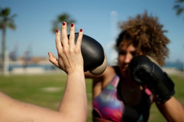 Parkta boks antrenmanı yapan sporcu kadınlar fitness ve nefsi müdafaa üzerine odaklanıyorlar.
