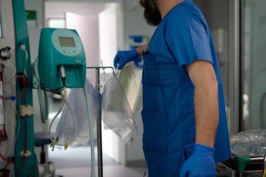 Bir hastane odasında hasta tedavisi için damar içi sıvılar hazırlayan doktor