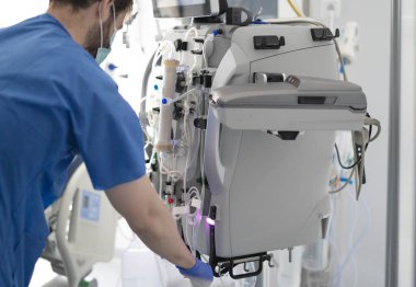 Modern bir hastane ortamında hayat kurtaran bir prosedür için tıbbi uzman diyaliz ekipmanları hazırlıyor.