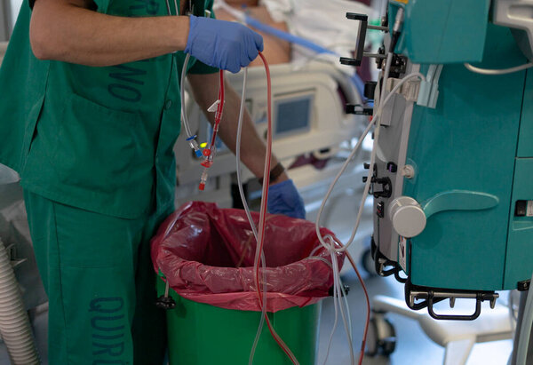 Hospital worker managing post-dialysis waste, highlighting hygiene protocols in healthcare settings