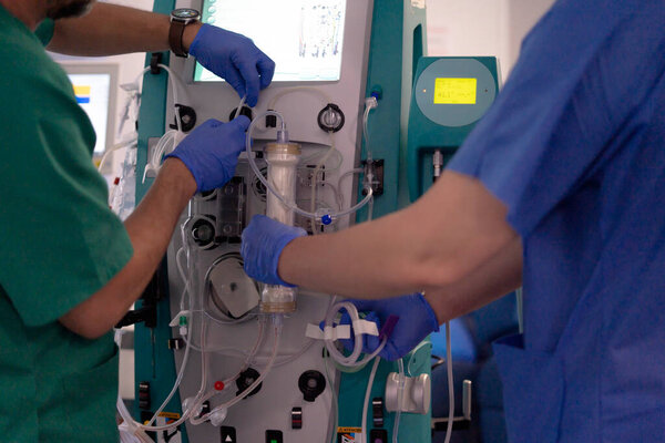 Healthcare workers using dialysis equipment in a clinical setting