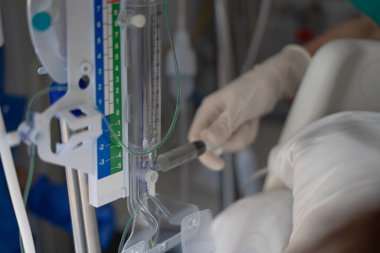 Tıbbi profesyonellerin seruma ilaç enjekte etmesi, hastane ortamında kritik bakım prosedürleri göstermesi.