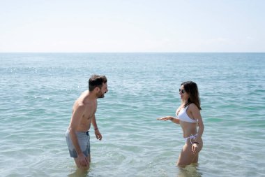 Çiftler yaz tatilinde denizde banyo yaparken eğleniyorlar.