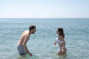 Çift yaz tatilinde denizde eğleniyor, ferahlatıcı suyun ve birbirlerinin arkadaşlığının tadını çıkarıyor.