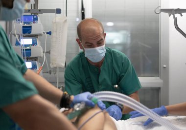 Doktorlar hastayı solunum tüpü ve tıbbi ekipman kullanarak ameliyathanede entübe ediyor.