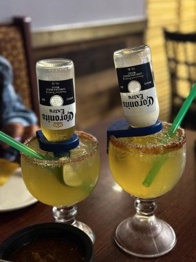 İki bira margarita, baş aşağı Corona şişeleri, limon dilimleri ve tuzlanmış jantlar. Parti, bar ya da yaz içkisi temaları için mükemmel.