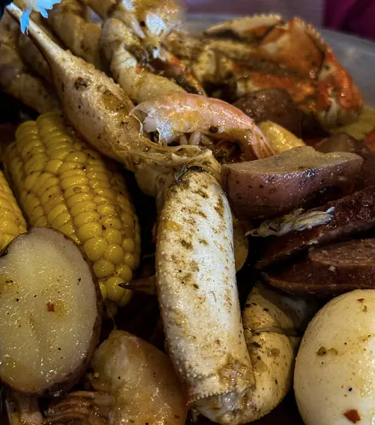 Yengeç bacağı, karides, mısır, kırmızı patates ve baharat içeren doyurucu bir deniz mahsulü haşlama, sıcak ve güney usulü bir ziyafette servis edilir..