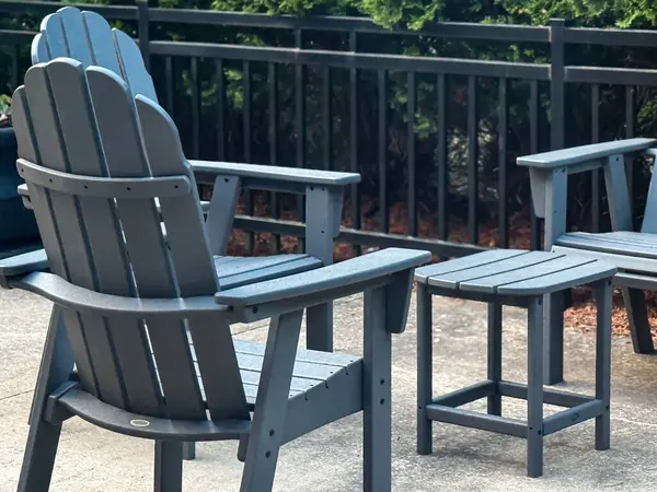 Gri Adirondack sandalyeleri yumuşak ışıkta verandada, huzurlu bir açık hava yaşantısı, rahatlama ve yaz tatili öneriyor arka bahçede ya da tatil beldesinde.