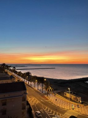 Akdeniz 'in üzerinde gün batımında kumsalın penceresinden bir manzara.