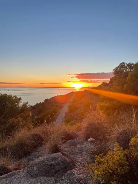 İspanya kıyı şeridinden deniz üzerinde nefes kesen bir gün batımı.