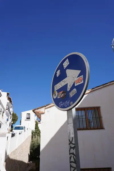 Yazın mavi gökyüzüne ve beyaz evlere karşı mavi bir yol tabelası