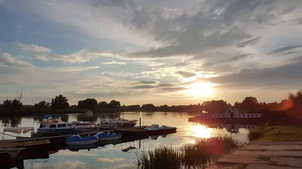 Küçük bir limandaki nehrin üzerinde nefes kesici bir gün batımı.