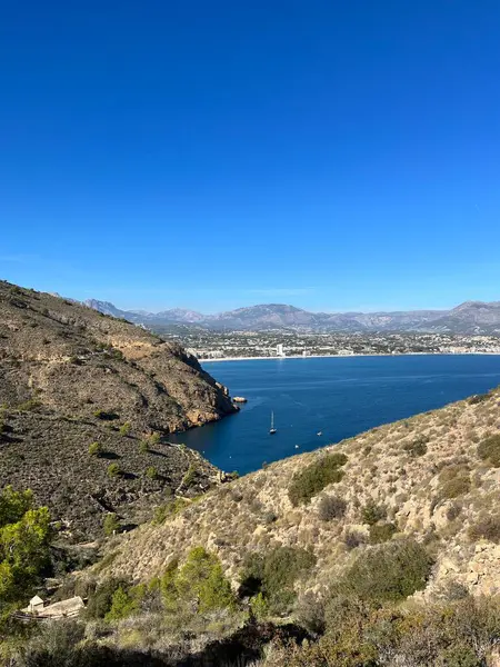 Deniz kıyısından güzel bir manzara, bir körfez ve bir İspanyol şehrindeki dağlar.