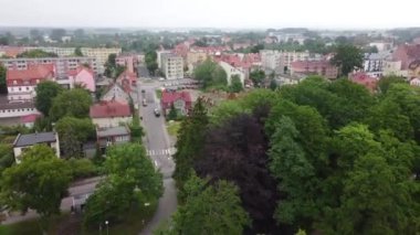 Şehrin ufuk ve orman manzarasıyla geriye doğru uçan bir dron görüntüsü.