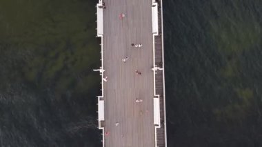 Deniz kenarındaki bir gezinti alanında turistlerin dolaştığı bir İHA fotoğrafı.