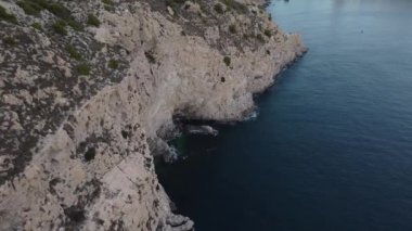 İspanya 'da Akdeniz' in üzerinde yüksek bir uçurumun kenarından uçan bir dron.