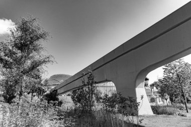 Zaryadie parkında Moskova 'da bir köprü. Arkasında bir bina var. Köprü yolun üzerinde. Gökyüzü bulutlu.