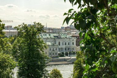 Moskova 'da Kremlin' de ortasında büyük beyaz bir bina bulunan bir şehir manzarası. Binanın yeşil bir çatısı var.