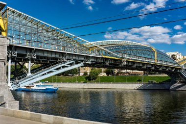 Moskova nehri üzerinde bir köprü ve Moskova Rusya 'nın arka planında bir şehir. Köprü metalden yapılmıştır ve bir sürü ışığı vardır.