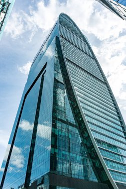 Moskova 'da bir sürü penceresi ve gökyüzünün yansıması olan yüksek bir bina. Moskova Rusya 'da gökyüzü mavi ve bulutlu.