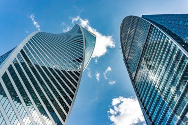 Moskova 'da bir sürü penceresi ve gökyüzünün yansıması olan yüksek bir bina. Moskova Rusya 'da gökyüzü mavi ve bulutlu.