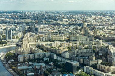Moskova 'da içinden Moskova nehri akan bir şehir. Nehir binalar ve ağaçlarla çevrilidir. Nehirde kayıklar ve arka planda bir vinç var.