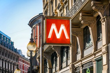 Milan İtalya 'daki metro tabelası. Üzerinde M harfi olan kırmızı beyaz bir tabela. Tabela bir direğe asılı.