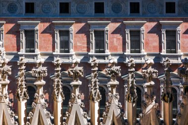 Milano İtalya. Bir sürü penceresi ve bir sürü süsü olan bir bina. Bina kırmızı. Pencereler beyaz.