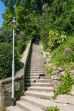 Sokak lambası ve merdiveni olan bir sokak. Basamaklar betondan yapılmış. Lamba direği merdivenlerin solunda.