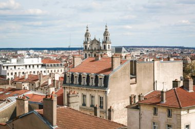 Birçok binası ve büyük bir kilisesi olan Nancy France şehri. Binaların çoğu kırmızı. Gökyüzü bulutlu.