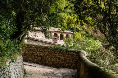 San Damiano Kilisesi ve 12. yüzyıldan kalma manastır ve iddiaya göre İsa 'nın Francis Assisi ile konuştuğu yer. Dağda yeşil ağaçların arasında bir kilise
