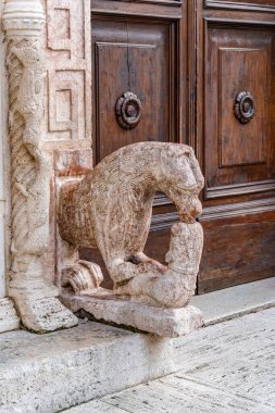 İtalya 'nın Umbria kentindeki Assisi şehrindeki taş bir sütuna taş bir at heykeli bağlanmış. Heykel aslan başıyla oyuluyor ve taş bir çıkıntıya yerleştiriliyor.