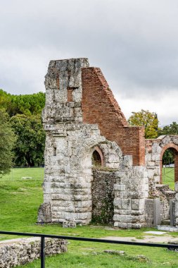 Gubbio İtalya Umbria 'da kemerli pencereleri ve avlusu olan büyük bir taş bina. Avlu bir çitle çevrili. Gubbio 'daki Roma Tiyatrosu Arkeoloji Parkı.