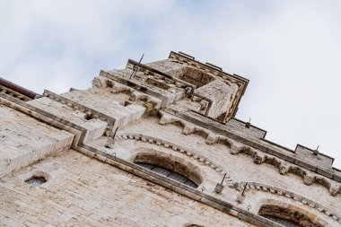 Gubbio İtalya 'da bir çan kulesi. Umbria' nın tepesinde çan var. Çan kulesi bir ağacın yanında. Ağacın üzerinde elma var.