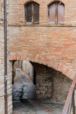 Gubbio, Umbria İtalya 'da demir parmaklıklı tuğla kemer. Kemer yolu dardır ve taş zemini vardır.