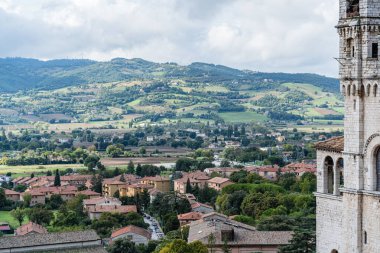 Gubbio İtalya 'nın birçok binası ve arkasında büyük bir tepesi olan Umbria şehri. Binalar taştan yapılmış ve kırmızı çatılı.