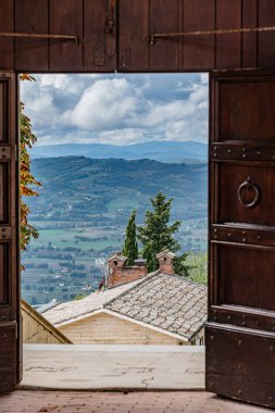 Gubbio Bakış açısı İtalya Umbria 'daki dağları gören ahşap bir kapı. - Kapı açık. Kapıda bir ışık var.